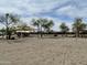 Sandy community volleyball court with a net, trees, and a nearby playground at 18502 N Celis St, Maricopa, AZ 85138