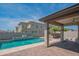 Backyard pool with outdoor kitchen, pergola, tiled patio and perimeter wall at 18925 W Windsor Blvd, Litchfield Park, AZ 85340