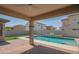 Covered patio overlooking a refreshing pool with an artificial-turfed yard at 18925 W Windsor Blvd, Litchfield Park, AZ 85340