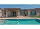 Inviting backyard pool featuring cool blue water, a brick patio, and a covered patio at 18925 W Windsor Blvd, Litchfield Park, AZ 85340