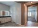 Bright bathroom features an illuminated mirror, double sinks and access to a bedroom at 18925 W Windsor Blvd, Litchfield Park, AZ 85340