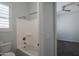 Bathroom with shower-tub combo, white walls and window with shutter at 18925 W Windsor Blvd, Litchfield Park, AZ 85340