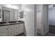 A bathroom with double sinks and vanity, plus a view into a shower and doorway to another room at 18925 W Windsor Blvd, Litchfield Park, AZ 85340