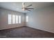 Neutral bedroom with natural light, plantation shutters, a ceiling fan, and plush carpeting at 18925 W Windsor Blvd, Litchfield Park, AZ 85340