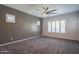 Another view of the cozy carpeted bedroom with ceiling fan and plantation shutters at 18925 W Windsor Blvd, Litchfield Park, AZ 85340