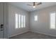 Bedroom featuring a ceiling fan, two windows with plantation shutters and tile flooring at 18925 W Windsor Blvd, Litchfield Park, AZ 85340