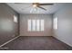 Spacious bedroom featuring a ceiling fan and three windows with plantation shutters at 18925 W Windsor Blvd, Litchfield Park, AZ 85340