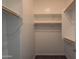 Bright walk-in closet features built in shelving and wood closet rods at 18925 W Windsor Blvd, Litchfield Park, AZ 85340