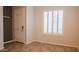 Bright entryway featuring neutral tile flooring, white trim and window shutters, and a paneled front door at 18925 W Windsor Blvd, Litchfield Park, AZ 85340