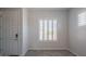 Inviting entryway with gray tile flooring, white walls, front door, and window with shutter at 18925 W Windsor Blvd, Litchfield Park, AZ 85340