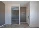 Hallway with neutral gray walls, tile flooring, and doorways to living space at 18925 W Windsor Blvd, Litchfield Park, AZ 85340