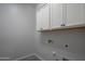 Bright laundry room with white cabinetry and utility connections for modern appliances at 18925 W Windsor Blvd, Litchfield Park, AZ 85340