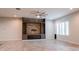 Bright living room with a stone-accented wall with built-in shelving, an electric fireplace, and tile flooring at 18925 W Windsor Blvd, Litchfield Park, AZ 85340