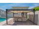 View of backyard covered outdoor kitchen with grill, sink, cabinets and stone accents at 18925 W Windsor Blvd, Litchfield Park, AZ 85340