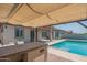 Angle view of outdoor kitchen with pergola and lighting adjacent to the pool at 18925 W Windsor Blvd, Litchfield Park, AZ 85340