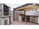 Outdoor kitchen featuring a built-in grill, counter space, stainless steel cabinets, and a shaded pergola at 18925 W Windsor Blvd, Litchfield Park, AZ 85340