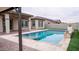 Backyard pool with patio, covered seating, and outdoor landscaping, perfect for cooling off in the heat at 18925 W Windsor Blvd, Litchfield Park, AZ 85340