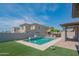 Backyard pool with outdoor kitchen, pergola, tiled patio and perimeter wall at 18925 W Windsor Blvd, Litchfield Park, AZ 85340