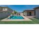 Backyard pool with outdoor kitchen, pergola, and tiled patio at 18925 W Windsor Blvd, Litchfield Park, AZ 85340