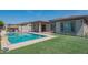 Backyard pool with artificial turf, tiled patio and outdoor kitchen with covered pergola at 18925 W Windsor Blvd, Litchfield Park, AZ 85340