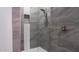 Close-up of remodeled shower featuring gray tile with a built-in niche at 18925 W Windsor Blvd, Litchfield Park, AZ 85340