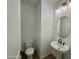Clean and modern powder room featuring a pedestal sink, oval mirror, and updated lighting at 1909 W Lariat Ln, Phoenix, AZ 85085