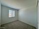 Bright bedroom featuring neutral carpet, fresh white walls, and natural light from window at 1909 W Lariat Ln, Phoenix, AZ 85085