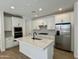 Gourmet kitchen features white cabinets, stainless steel appliances, a central island, and quartz counters at 1909 W Lariat Ln, Phoenix, AZ 85085