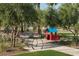 A dedicated play area features a colorful playhouse, picnic table, and bike rack amid lush landscaping at 1909 W Lariat Ln, Phoenix, AZ 85085