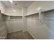 A walk-in closet with ample shelving and carpeted flooring for organized storage at 1909 W Lariat Ln, Phoenix, AZ 85085