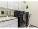 Bright laundry room features a large sink and side by side black washer and dryer at 1926 W Wayne Ln, Anthem, AZ 85086