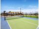 Well-maintained tennis court with green and blue surfaces, surrounded by landscaping and a clear blue sky at 20901 S 231St Way, Queen Creek, AZ 85142