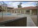 View of community pool, spa, and lounging area from covered patio at 2220 W Dora St # 114, Mesa, AZ 85201