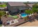 Aerial view of the backyard of the house with a putting green, a pool and a fire pit with chairs at 22338 N O Sullivan Dr, Maricopa, AZ 85138