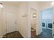 Hallway leading to laundry room and powder room with neutral paint and tile floors at 22338 N O Sullivan Dr, Maricopa, AZ 85138