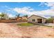 A dirt backyard enclosed by a brick wall and a covered patio with artificial turf, ideal for outdoor activities at 2376 E Rosario Mission Dr, Casa Grande, AZ 85194