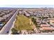 Overhead shot showcasing a planned community with green spaces, road access, and numerous homes with solar panels at 23830 W Romley W Ave, Buckeye, AZ 85326