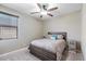 Comfortable bedroom with a ceiling fan, window, and matching nightstand at 23830 W Romley W Ave, Buckeye, AZ 85326