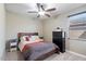 This bedroom showcases neutral walls, a ceiling fan, and a window overlooking the neighborhood at 23830 W Romley W Ave, Buckeye, AZ 85326