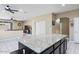 Kitchen island featuring granite countertop and dark cabinets, with view to living area at 23830 W Romley W Ave, Buckeye, AZ 85326