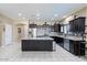 Spacious kitchen featuring dark cabinetry, granite countertops, a central island, and stainless steel appliances at 23830 W Romley W Ave, Buckeye, AZ 85326