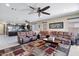 Spacious living room featuring multiple sofas, ceiling fan, and open layout to the kitchen at 23830 W Romley W Ave, Buckeye, AZ 85326