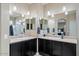 This main bathroom features two sinks, dark cabinets, and access to the private shower at 23830 W Romley W Ave, Buckeye, AZ 85326