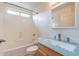 Functional bathroom featuring a single sink vanity and tub with a window at 2439 W White Feather Ln, Phoenix, AZ 85085