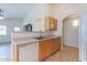 Well-organized kitchen with wood cabinets, a dishwasher, and an open view to living area at 2439 W White Feather Ln, Phoenix, AZ 85085