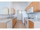 Functional kitchen layout with light wood cabinetry and essential white appliances at 2439 W White Feather Ln, Phoenix, AZ 85085