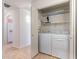 Bright laundry room featuring a white washer and dryer, accessible shelving, and a spacious layout at 2439 W White Feather Ln, Phoenix, AZ 85085