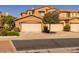 View of the townhome exterior featuring a private two-car garage and desert landscaping at 250 W Queen Creek Rd # 146, Chandler, AZ 85248