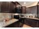 Contemporary kitchen featuring granite countertops, dark cabinetry, stainless steel appliances, and tile backsplash at 2748 W Sunland Ave, Phoenix, AZ 85041