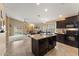 Modern kitchen with a central island, dark wood cabinets, open to a cozy living area and a sliding door at 2748 W Sunland Ave, Phoenix, AZ 85041